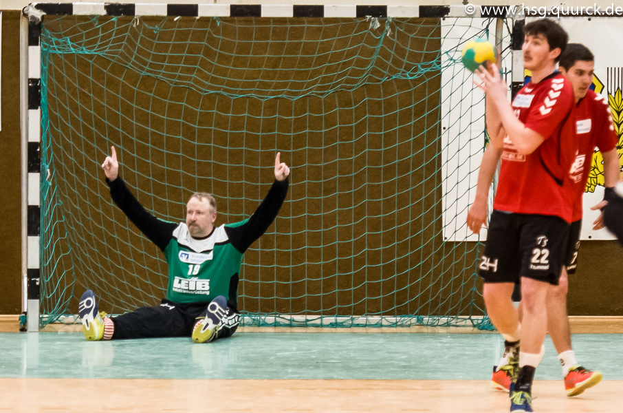 Sitzender Torwart hebt jubelnd die Arme